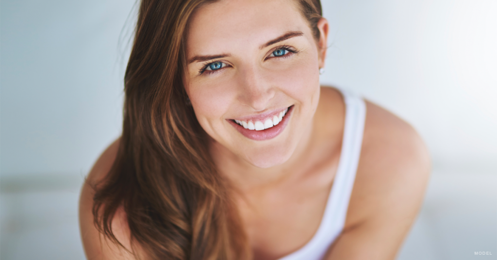 Woman in tank top looking up and smiling