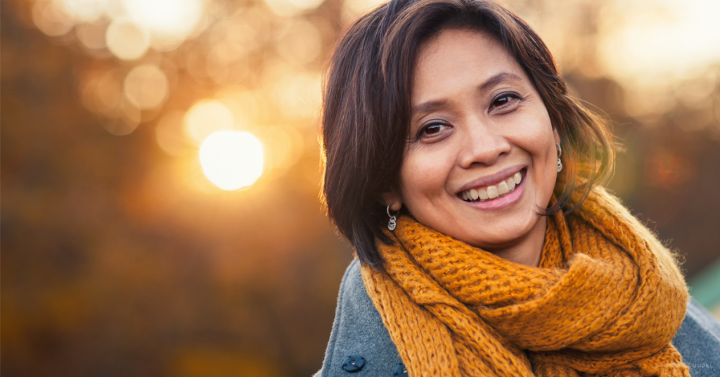 Brunette woman smiling after getting dermal fillers.