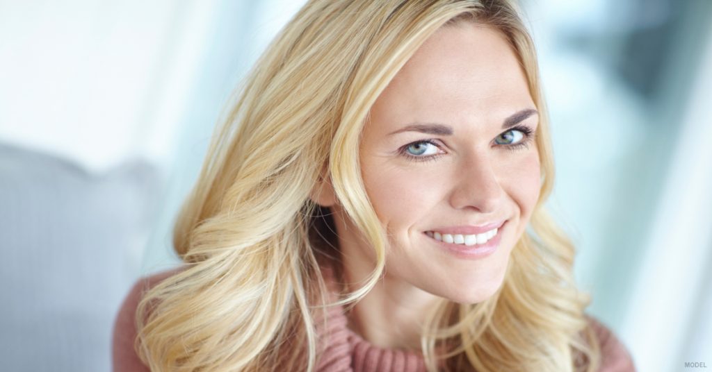 Face of smiling woman with blonde hair and smooth skin