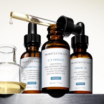 Three bottles of SkinCeutical serums with dropper dripping