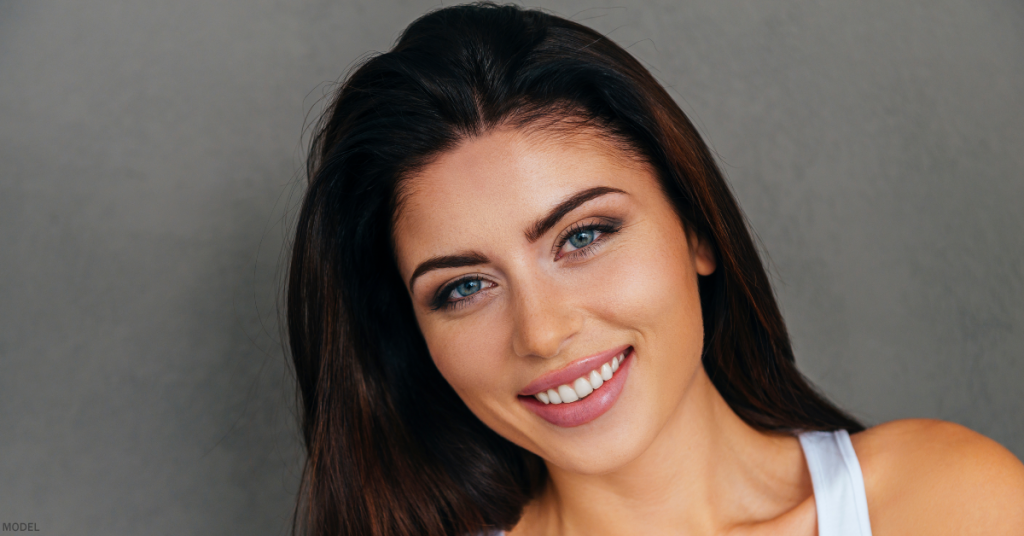 Woman from shoulders up smiling with head slightly tilted