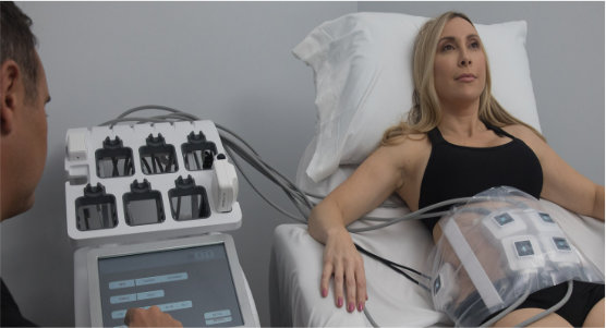 A woman demonstrating the setup of TruSculpt on her abdomen.