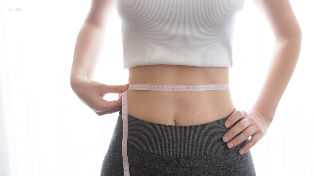 woman measuring her waist to track weight loss